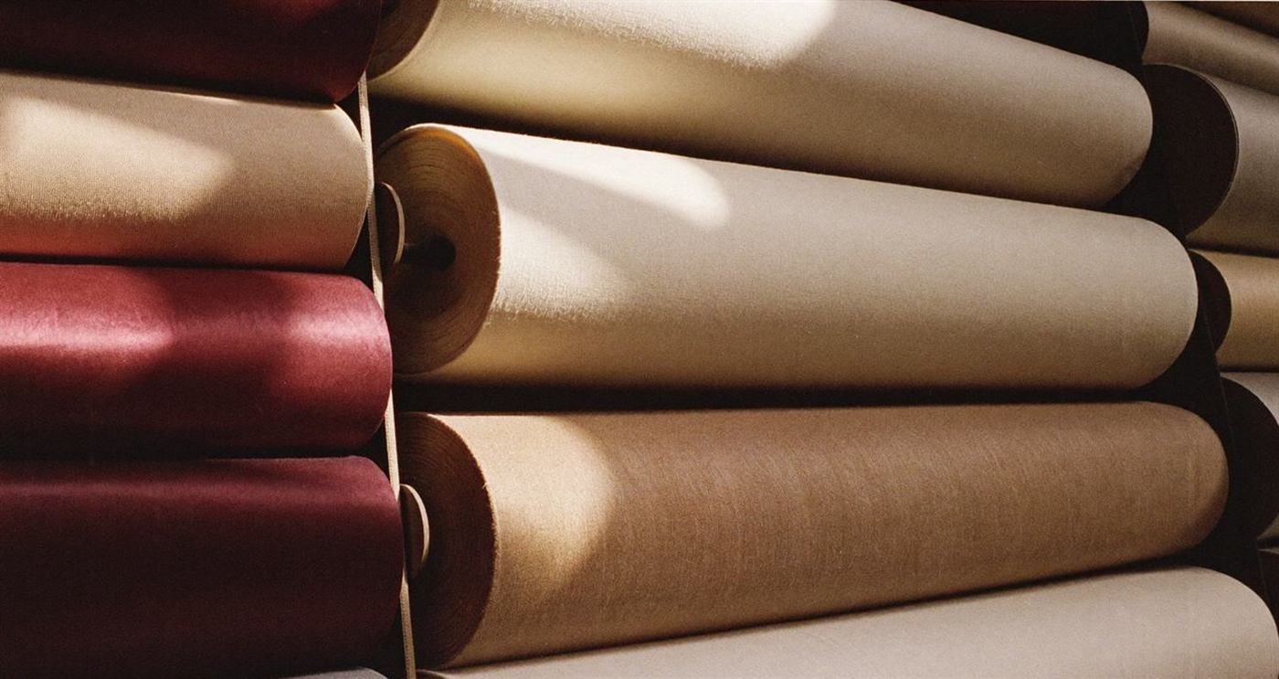Rolls of burgundy, ivory and taupe fabric in the Milana atelier