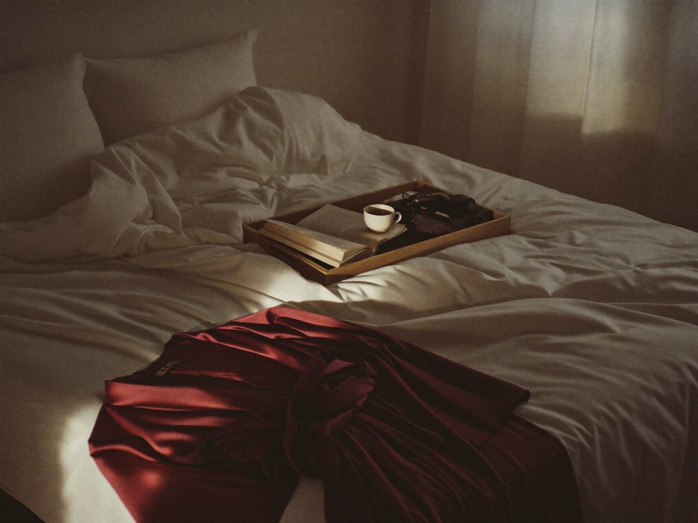 Breakfast tray on rumpled ivory linen with a silk robe